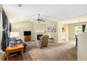 Cozy living room with a fireplace, vaulted ceiling, and neutral carpet, creating a welcoming atmosphere at 4326 Megan Manor Sw Dr, Powder Springs, GA 30127