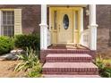Close-up of a front door with sidelights, brick steps, and manicured landscaping at 5152 Clearwater Dr, Stone Mountain, GA 30087