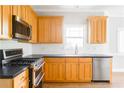 Modern kitchen with stainless steel appliances, ample wood cabinetry, and sleek countertops at 1115 Third St, Stone Mountain, GA 30083