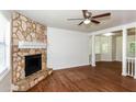 Cozy living room featuring a stone fireplace, hardwood flooring, and bay windows at 2636 Suzanne Ln, Acworth, GA 30102