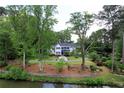 Beautiful home nestled amongst mature trees, features a serene waterfront view at 3109 Country Lake Dr, Powder Springs, GA 30127