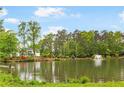 Scenic view of the pond with a fountain and lush trees surrounding the property at 3109 Country Lake Dr, Powder Springs, GA 30127