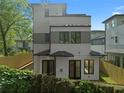 Exterior elevation featuring the rear of a modern home with clean lines, light siding, and private fencing at 90 Cleveland Unit B Se St, Atlanta, GA 30316