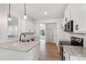 The kitchen features stainless steel appliances, granite countertops, and white cabinetry at 2279 Lakeview Pkwy, Villa Rica, GA 30180