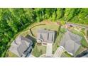 Aerial view of a well-maintained home with a lush green lawn and surrounding mature trees at 242 Fieldbrook Xing, Canton, GA 30115