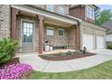 Charming covered front porch with brick columns and a cozy seating area at 242 Fieldbrook Xing, Canton, GA 30115