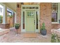 Inviting front entrance features a green door, brick facade, and decorative potted plants at 2853 N Thompson Ne Rd, Brookhaven, GA 30319
