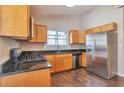 Modern kitchen with stainless steel appliances, granite countertops, and natural wood cabinets at 5379 Winslow Xing, Lithonia, GA 30038