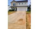 Two-story home featuring a two-car garage and a concrete driveway at 713 Dove Tree Ln, Social Circle, GA 30025