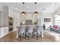 Bright, modern kitchen with white cabinets, stainless appliances, island with seating, and open to the living area at 963 Forrest St, Roswell, GA 30075