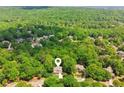 A lush aerial view of the home nestled amongst mature trees on a spacious lot at 4050 Arrow Head Trl, Cumming, GA 30041