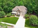 Beautiful home on a large lot featuring stone accents, a three-car garage, and pristine landscaping at 4050 Arrow Head Trl, Cumming, GA 30041