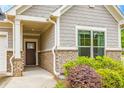 Close up of the exterior featuring a dark brown front door with a beige stone and siding facade at 463 Marston Pass, Acworth, GA 30102