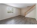 Bright living room featuring hardwood floors, large window, and a classic staircase at 6900 Roswell Rd # F6, Atlanta, GA 30328