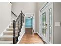 Inviting foyer with hardwood floors, staircase, decorative glass front door, and views to other rooms at 5344 Saint Martins Se Ct, Mableton, GA 30126