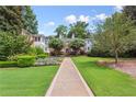 Beautifully landscaped front walkway leading to a brick building with mature trees and colorful flowers at 115 Peachtree Memorial Nw Dr # C1, Atlanta, GA 30309