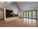 Modern living room with a stone fireplace, built-in shelves, and access to screened porch at 71 Ramey Rd, Sugar Hill, GA 30518