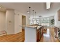 Open-concept kitchen showcasing stainless steel appliances, a breakfast bar, and hardwood floors at 10898 Gallier St, Johns Creek, GA 30022