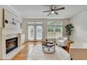 Bright living room featuring a fireplace, hardwood floors, modern décor, and doors leading to a deck at 10898 Gallier St, Johns Creek, GA 30022