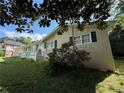 Side view of a well-kept home featuring a landscaped yard and blooming roses at 237 Sandra Nw Dr, Lilburn, GA 30047