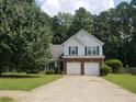Charming two-story home featuring a well-manicured lawn, mature trees, and an attached two-car garage at 3416 N Cook Rd, Powder Springs, GA 30127