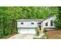 Charming split-level home nestled in a lush, green landscape with a two-car garage and inviting front entrance at 832 Wyntuck Nw Dr, Kennesaw, GA 30152