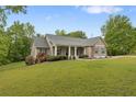 Charming home with a welcoming front porch, beautiful landscaping, and a well-manicured lawn at 109 J O Simmons Path, Douglasville, GA 30134