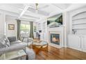 Elegant living room with coffered ceilings, a fireplace, built-in shelving, and hardwood floors at 2292 W Village Junction Se Way, Smyrna, GA 30080