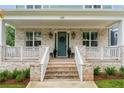Charming brick porch with white railings and stately front door with decorative wreath at 425 Harold Ne Ave, Atlanta, GA 30307