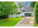 Well-maintained home with a driveway and a lush lawn, surrounded by mature trees at 1007 Natalie Se Ln, Smyrna, GA 30082