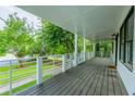 Spacious covered front porch with white railings overlooking a beautifully landscaped front yard at 1007 Natalie Se Ln, Smyrna, GA 30082