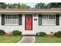 Up-close view of home entrance with red door, black shutters, manicured bushes, and clear house number at 2103 Blue Creek Ct, Conley, GA 30288