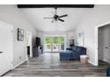 Bright living room with vaulted ceilings, wood floors, and access to the outdoor deck at 2103 Blue Creek Ct, Conley, GA 30288