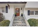 Elegant front entrance with stone steps leading to a wood door flanked by manicured shrubs at 3519 Sunderland Ne Way, Brookhaven, GA 30319