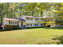 Inviting two-story home featuring a lush lawn and classic design with black shutters and a brick facade at 3519 Sunderland Ne Way, Brookhaven, GA 30319