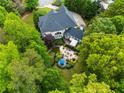 An aerial view shows a backyard with a putting green, a patio with seating and mature trees at 12815 Oak Falls Dr, Alpharetta, GA 30009