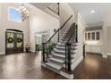 Elegant foyer features hardwood floors, a staircase, and a chandelier with abundant natural light at 12815 Oak Falls Dr, Alpharetta, GA 30009