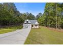 New home on a sprawling lawn, complete with a paved driveway and natural backdrop of trees at 1488 Campbell Rd, Covington, GA 30014