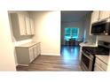 Modern kitchen boasts white cabinets, stainless steel appliances, and granite countertops at 710 Park Place Trl, Social Circle, GA 30025