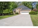 Charming home featuring a stone facade, well-manicured lawn, and a two-car garage with a long concrete driveway at 1593 Brynwood Nw Ct, Acworth, GA 30101