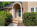 Inviting front entrance with stone archway, decorative columns, and a green front door at 1593 Brynwood Nw Ct, Acworth, GA 30101