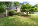 Beautiful lawn with lush green grass and a mature Japanese maple tree in front of a charming stone home at 1593 Brynwood Nw Ct, Acworth, GA 30101