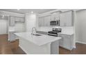 Modern kitchen featuring stainless steel appliances, gray cabinetry, and a quartz island at 464 Village Ln, Fairburn, GA 30213