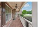 Inviting covered front porch with brick flooring, white railings, and a cozy ceiling fan at 1888 Sever Creek Cir, Lawrenceville, GA 30043