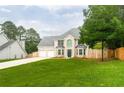 Attractive two-story home featuring a brick facade, lush lawn, and a driveway leading to the garage at 1976 Glen Echo Dr, Decatur, GA 30032