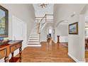 Elegant foyer with a curved staircase, hardwood floors, and soaring ceilings at 5335 Davenport Mnr, Cumming, GA 30041