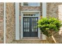 Inviting front entrance featuring double doors flanked by brick columns and lush greenery at 5335 Davenport Mnr, Cumming, GA 30041