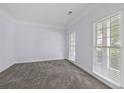 A sunlit room featuring neutral carpeting, fresh paint, and abundant light streaming in through the windows at 6131 Windflower Dr, Powder Springs, GA 30127