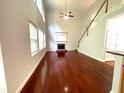 Living room with a fireplace, hardwood floors, and large windows offering plenty of natural light at 6131 Windflower Dr, Powder Springs, GA 30127