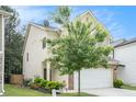 View of charming home with inviting landscaping, two-car garage, and traditional details at 6454 Grey Fox Way, Riverdale, GA 30296